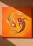 Wandbild mit zwei gold-orangefarbenen Koi-Fischen, die auf warmem orangefarbenem Hintergrund umeinander kreisen.